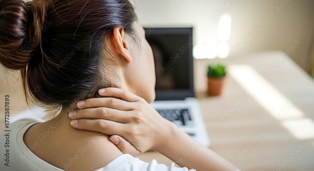 Fototapeta premium Woman suffering from neck pain while working on laptop 