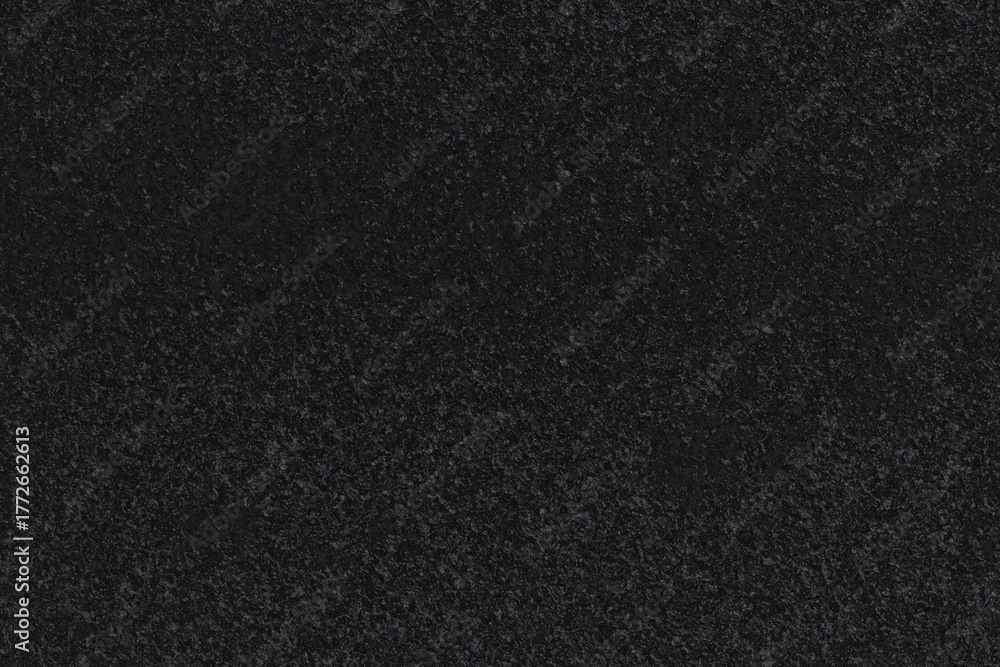 Fototapeta premium Textured black surface. Dark, slightly grainy appearance with subtle variations in tone. Uniform distribution of minuscule speckles