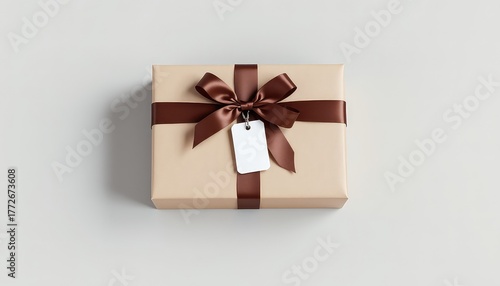 Wrapped present with a brown ribbon and a blank tag, set against a neutral backdrop providing ample surrounding space