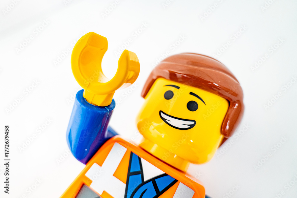 Fototapeta premium Bradford, UK Oct 30 2025 - Lego Emmet plastic toy shot close up on a white background. With one arm raised in greeting.