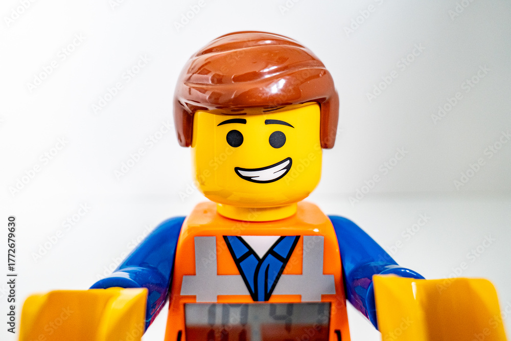 Obraz premium Bradford, UK Oct 30 2025 - Lego Emmet plastic toy shot close up on a white background. His arms raised forward embracing the camera.