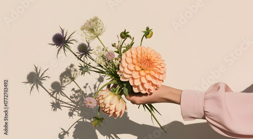 Hand holding a beautiful bouquet of flowers with dramatic shadows
