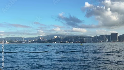 青空と海に包まれた香港の都市風景と穏やかな波