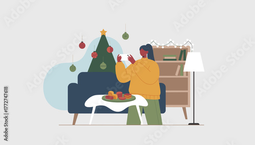 Woman photographing holiday food and Christmas tree decoration at home