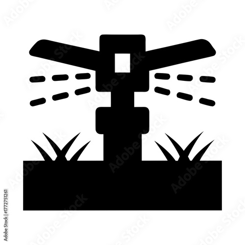 Black silhouette of a garden sprinkler watering grass