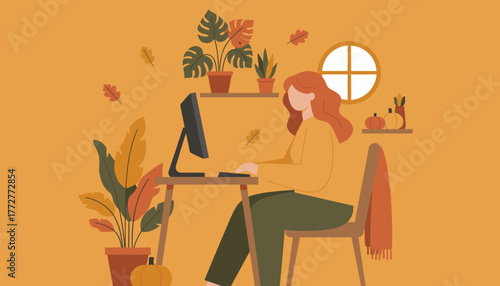 Woman working remotely at a desk in a cozy autumnal home office environment