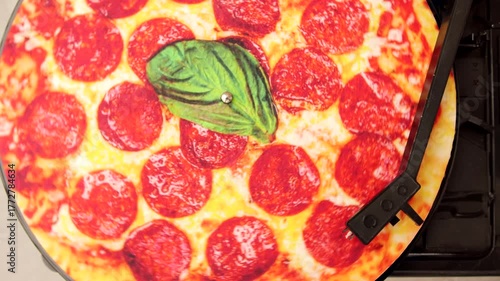 Pepperoni pizza as vinyl record rotating on turntable player.. Concept of retro technology, product advertising, social media content.