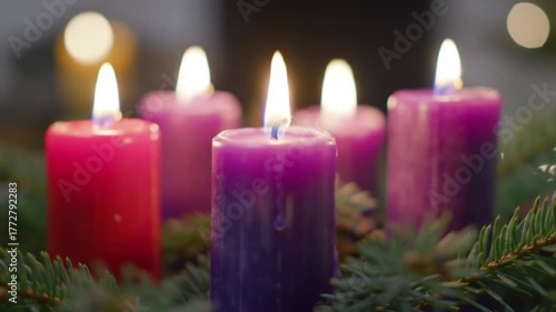 Advent wreath with burning candles in purple and pink.