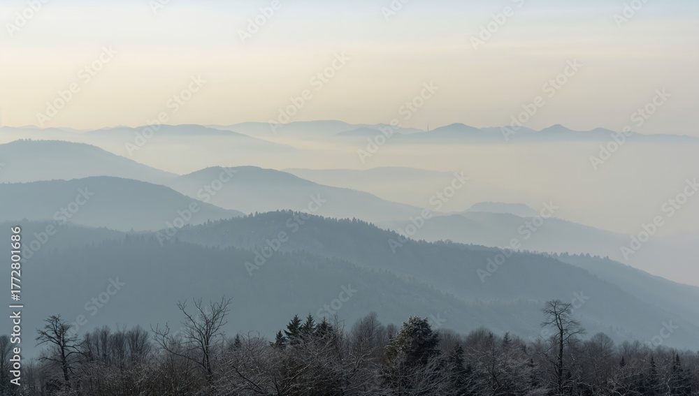 Obraz premium Mist-covered mountain layers extending into the horizon, seen from a nearby peak