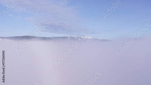 Discover breathtaking mountain peaks emerging from a sea of clouds in winter