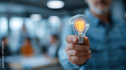 Business hand presenting creative strategy with lightbulb idea in meeting of professionals at table