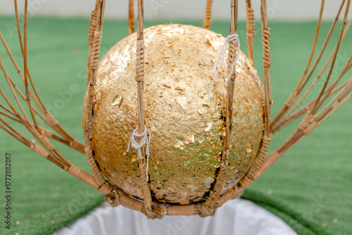 Photos Luk Nimit, Golden consecration ball used in Thai temple ceremony, symbolizing Bu