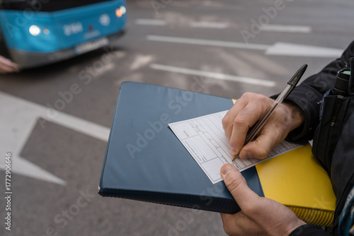 Fototapeta Naklejka Na Ścianę i Meble -  Police officer writing a ticket for a public transportation vehicle in madrid
