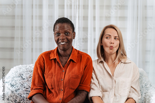 Tableau sur toile Two female friends making funny faces and smiling at camera