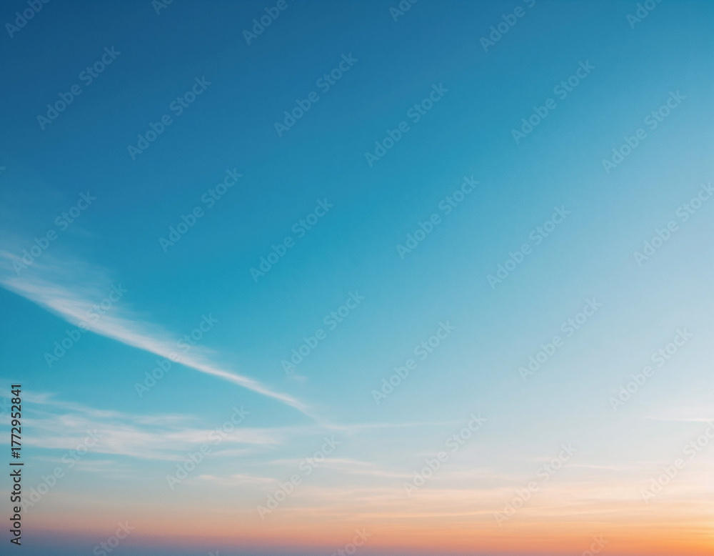 Obraz premium A serene skyscape, showcasing a gradient of colors from a vibrant orange to a clear, bright blue.
