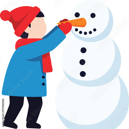 A child in winter clothing is building a snowman by placing a carrot as its nose.