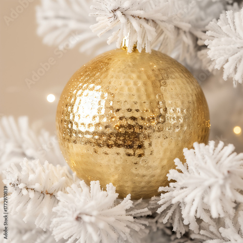 Close-up of a golden Christmas ornament on a white tree