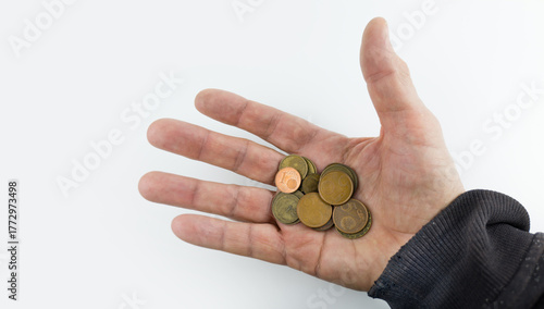 Homeless man hand with some change coins. Beggar hand concept on white background