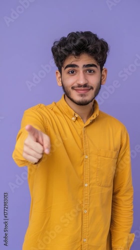 Wallpaper Mural A person in a bright yellow shirt pointing at the viewer, with a simple background Torontodigital.ca