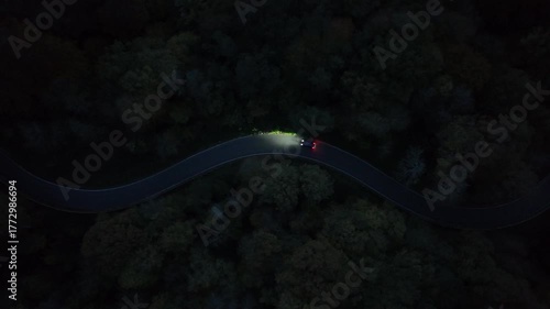 Curvy Forest Road at Night with Car Lights – Aerial View