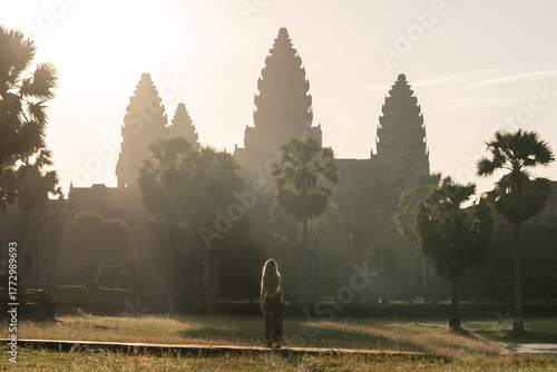 Woman traveling angkor wat admiring sunrise and historic temple