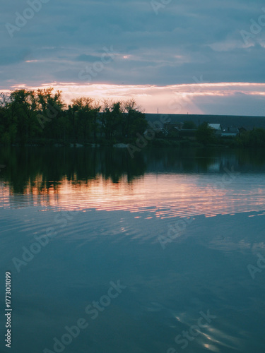 Low sun and birds shining across reservoir, quiet countryside evening