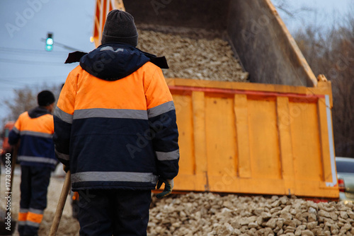 Site inspection underway, Worker examines gravel delivery