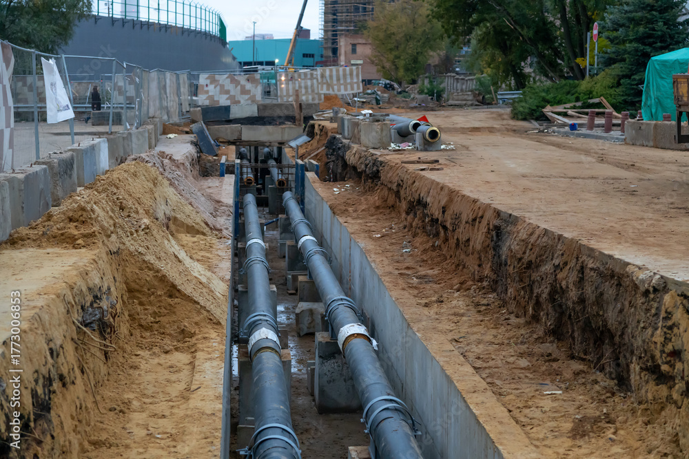Fototapeta premium Construction site with underground utility work in a city area during autumn