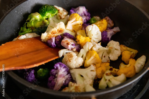 Colorful vegetables cooking in a skillet on a stove