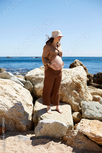 Pregnant woman embracing nature by the sea