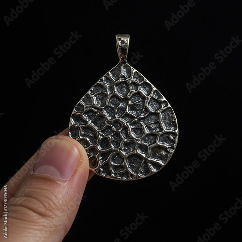 A close-up shot showing tactile exploration of an intricate metal pendant, emphasizing texture and sensory experience without sight ,intricate ,fashion ,art
