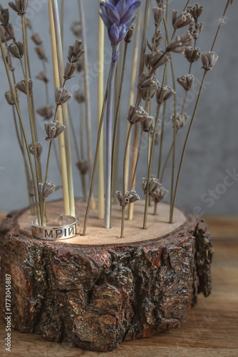 Wooden decor with dried wheat and lavender and a silver ring with the inscription 