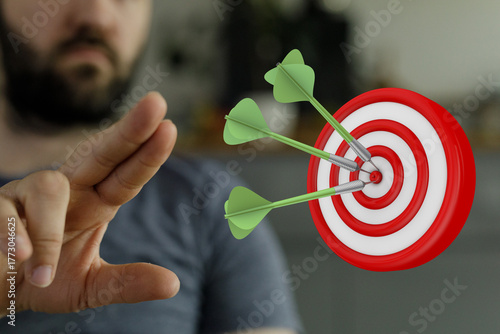 Close up of a hand and a darts target, achieving success, focus, aiming, strategy, hitting the target, business goals, concept, accuracy, precis