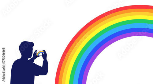 Silhouette of a person taking a photo of a rainbow.