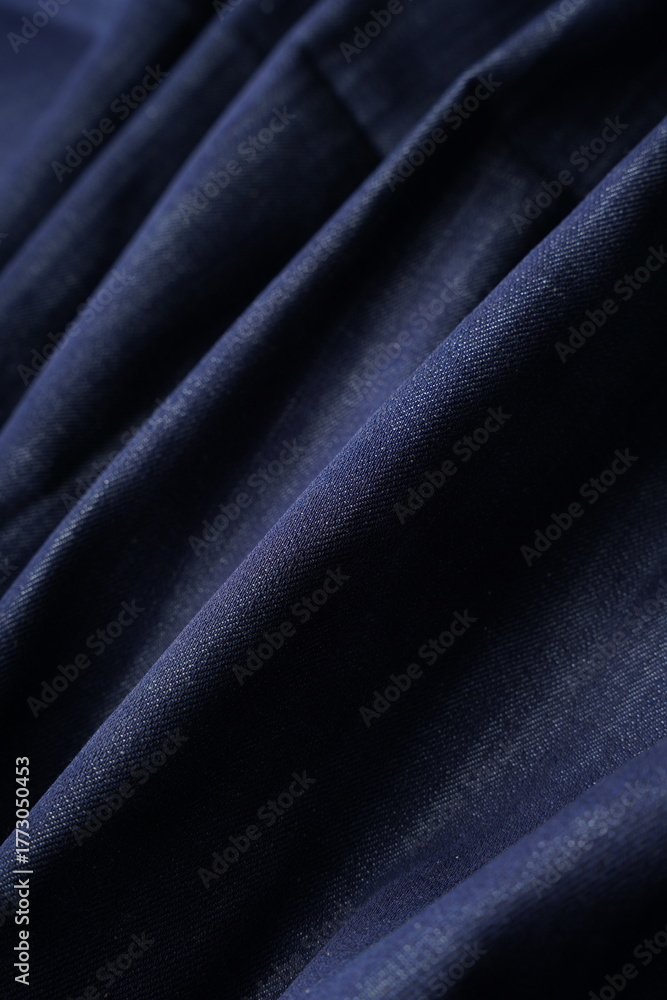 Obraz premium Wrinkled Denim Cloth Close-Up Texture Background. Detailed Denim Textile Background in Dark Blue Color. High Quality Denim Fabric Texture for Fashion and Textile Use. Indigo Denim Textile Background