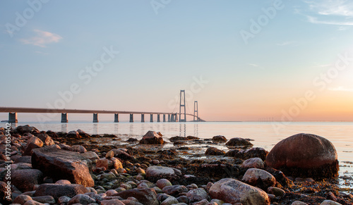 Great Belt Bridge View from a Rocky Beach Shore at Sunrise