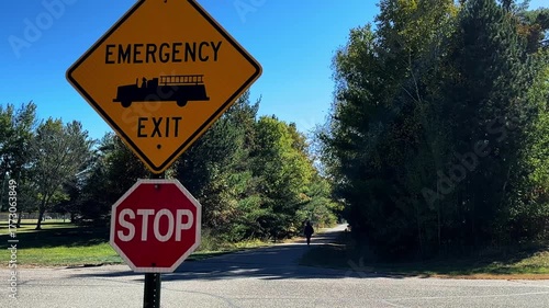 Two signs, Emergency Exit and Stop, are located on the Paul Bunyan Trail in Nisswa, Minnesota. The trail is popular with cyclists, walkers, runners, rollerbladers and snowmobilers.