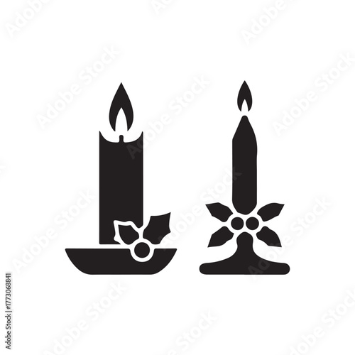 Two festive candles with holly decoration in a stark silhouette