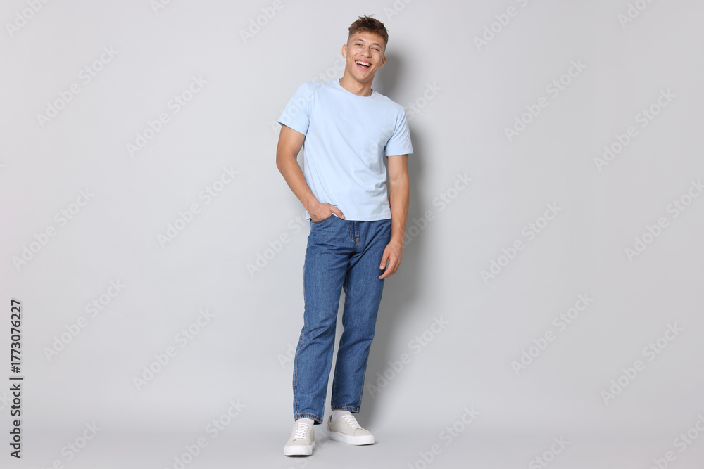 Fototapeta premium Handsome young man in stylish jeans on light grey background