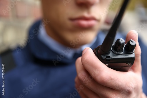 Foto Police officer with radio on city street, closeup