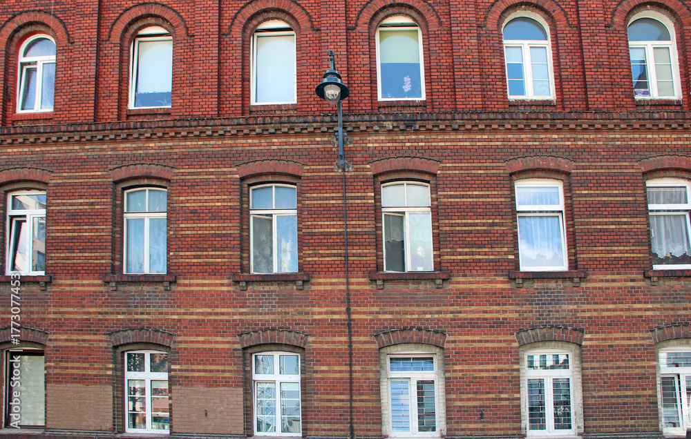 Obraz premium Building with many windows. Urban scene. City life. old red brick building