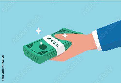 Dividends stock payment, passive income from dividend yield concept, rich and wealthy businessman hand holding pile of dollar money banknotes with the word Dividends.