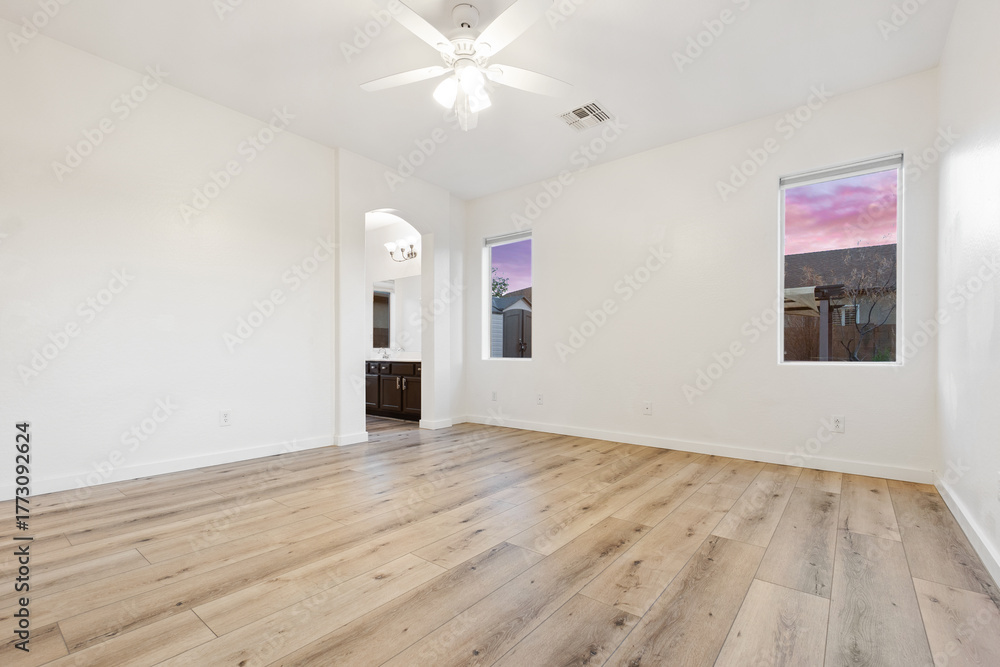 Fototapeta premium Spacious empty living room with hardwood floors and ceiling fan