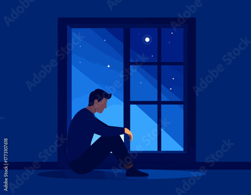 A man sits alone on the floor in a dark room, looking out a window at the night sky with stars and a moon.