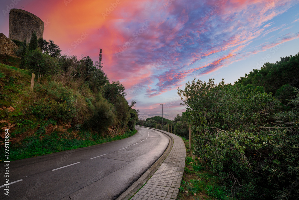 Fototapeta premium Road with a beautiful sunset in the background