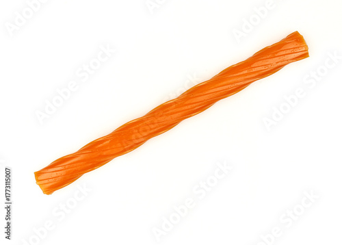 Single orange gummy licorice stick isolated on white background. Chewy liquorice treat