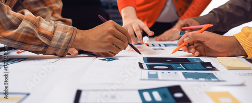 Engaged team members actively discuss and create user interface prototypes during a collaborative workshop, showcasing creativity and teamwork in a modern workspace environment. SACTR