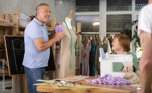 Vászonkép Smiling experienced male teacher in sixties leading sewing course for seniors, a