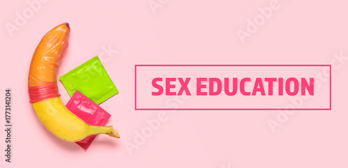 Condoms and banana on pink ...