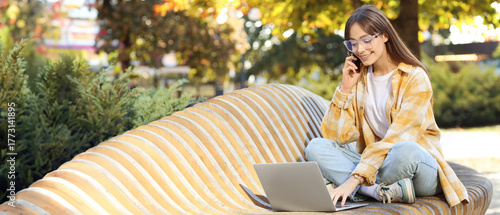 Young woman with laptop tal...